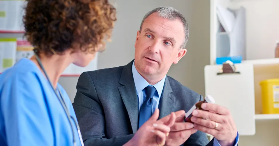 man in suit talking to healthcare worker